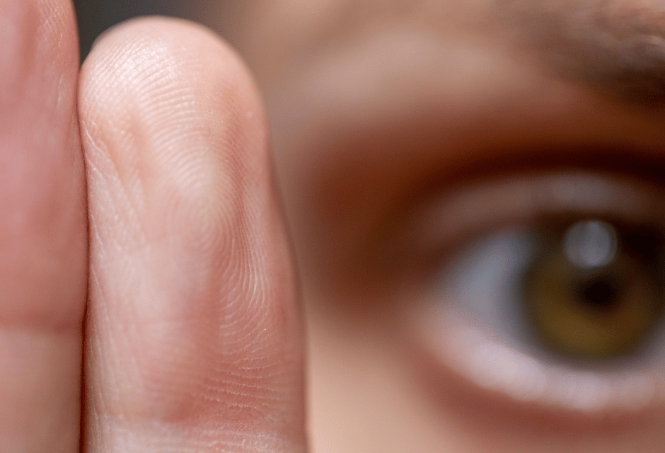 EMDR Extreme Nahaufnahme eines menschlichen Auges und dreier Finger mit sichtbarer Hautstruktur und feinen Linien.