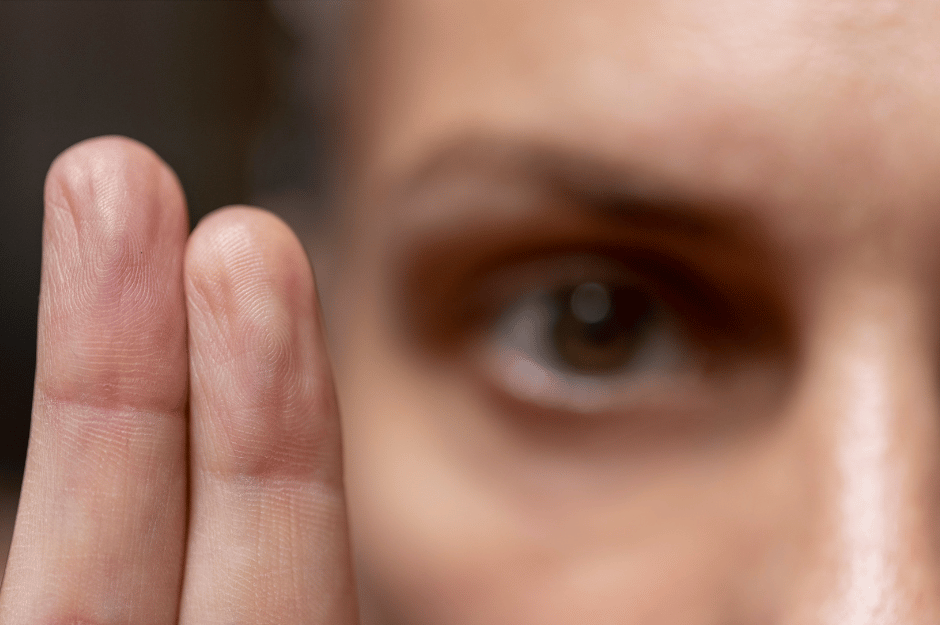 wingwave Nahaufnahme eines Auges und dreier Finger im Vordergrund, die feine Hautstruktur und Fingerabdrücke zeigen.